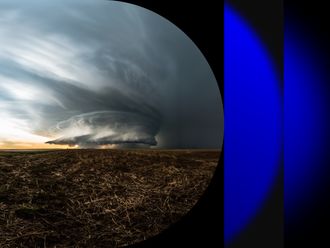 Photo of massive storm clouds and rain over a prairie
