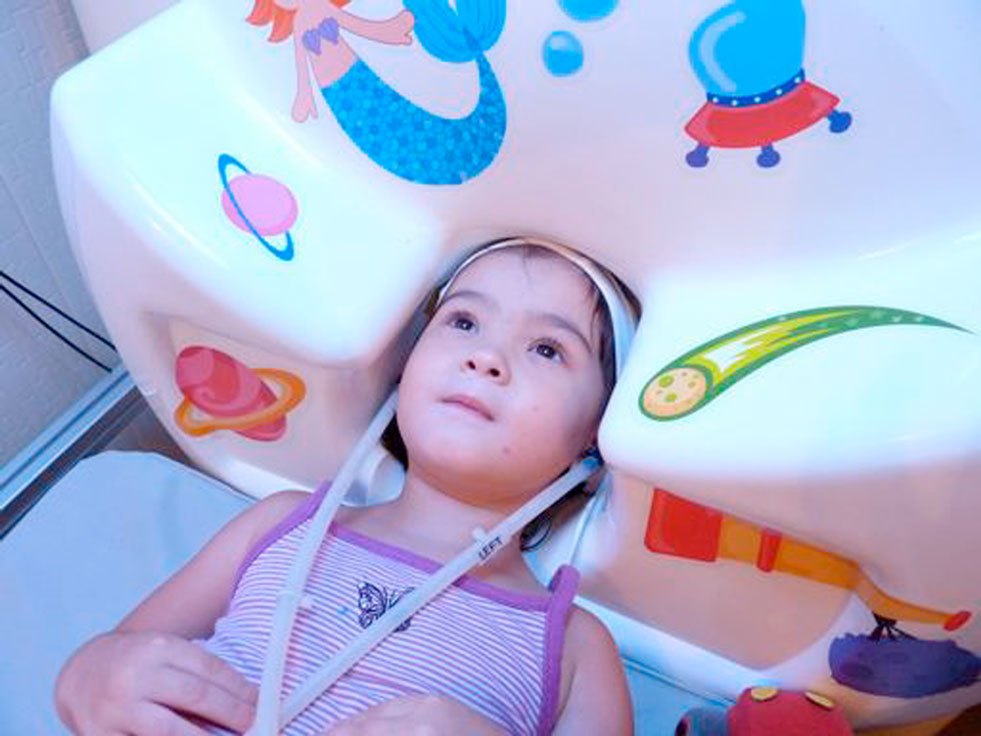 Figure 1 - A young girl undergoing an MEG recording.