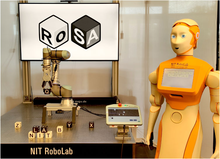 A robotic arm is sorting letter blocks on a table labeled