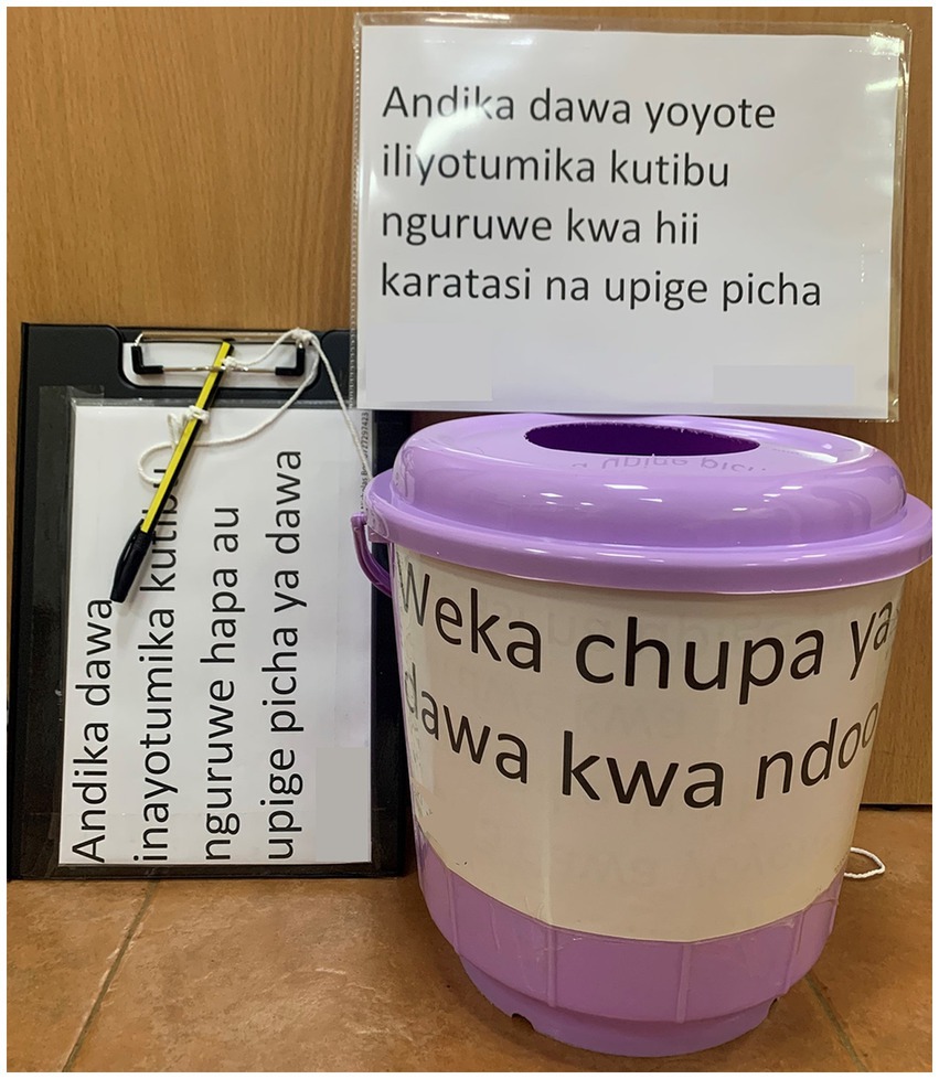 A purple container with Swahili instructions to place medicine bottles inside. A clipboard nearby has a paper and pen attached, with more Swahili instructions about recording medicine used for pigs.