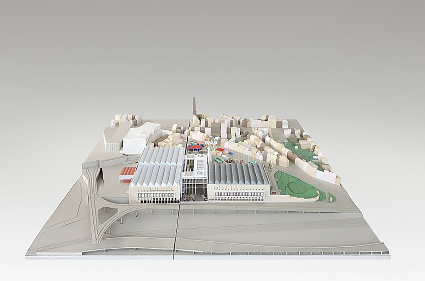 Architectural model showcasing a cityscape with an arranged grid of buildings. The model includes detailed structures, roads, and green spaces, highlighting a mix of urban and open areas.
