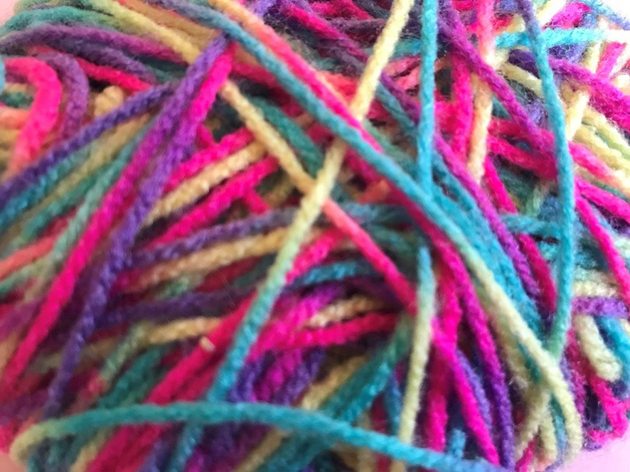 Closeup photograph of a ball of multicoloured wool.