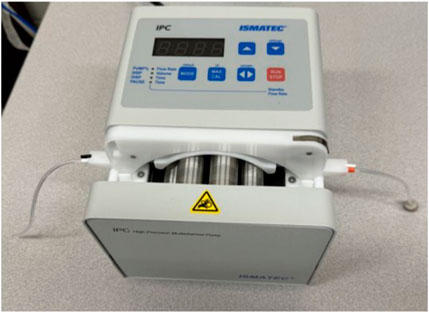 Image of a peristaltic pump with the cassette and Tygon tubing properly installed. The tubing is looped smoothly through the cassette, emphasizing the importance of avoiding creases that could disrupt fluid flow.
