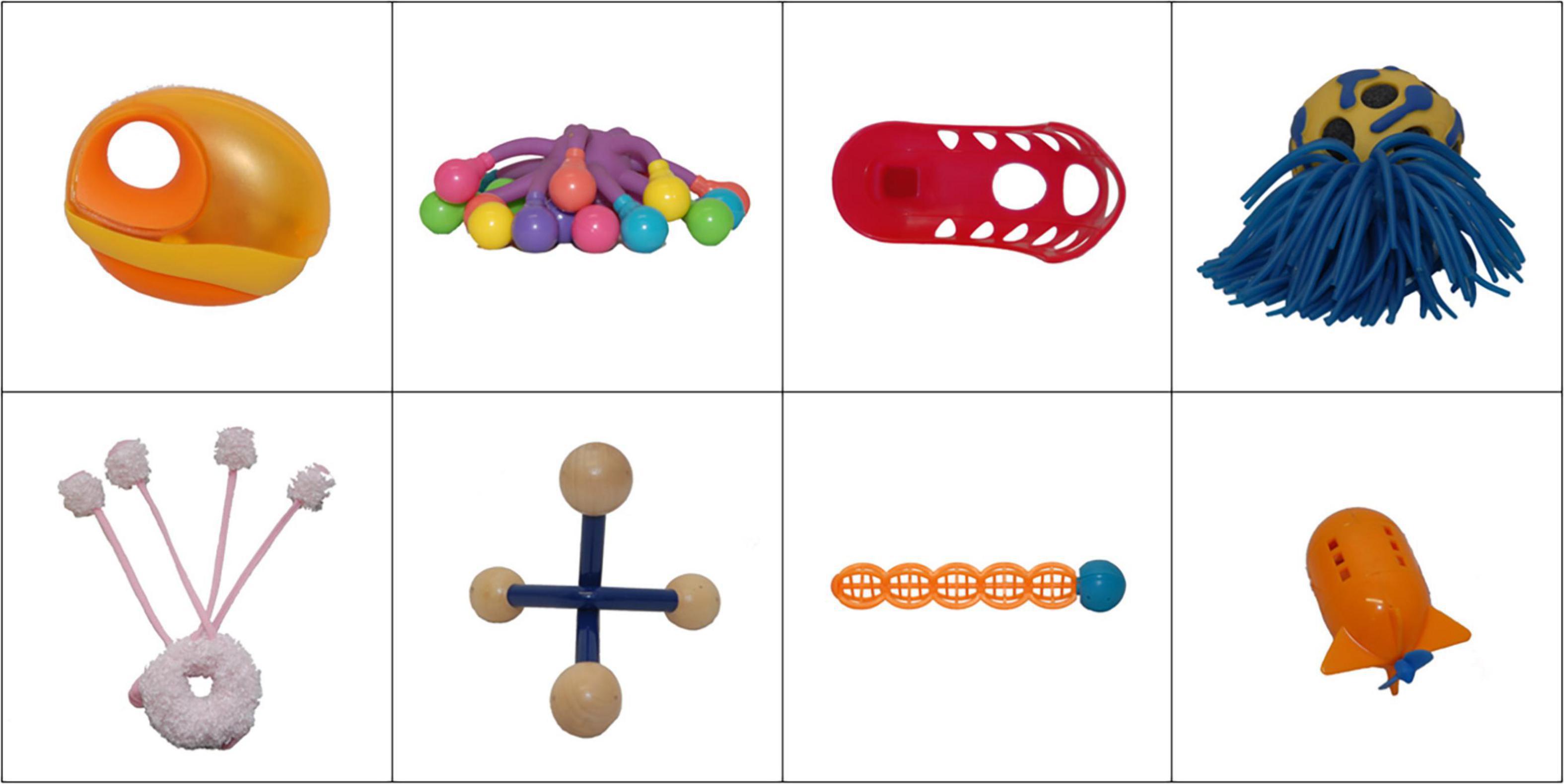 A grid of eight novel (nonsense) objects. Top row from left: orange object with a hole, colorful rubber octopus-like object, red object with holes, blue and yellow ball with tassels. Bottom row from left: white soft donut with light pink and white soft antennas, beige and blue four-pronged massager-like object, orange and blue ball with segments, orange rocket-shaped object.