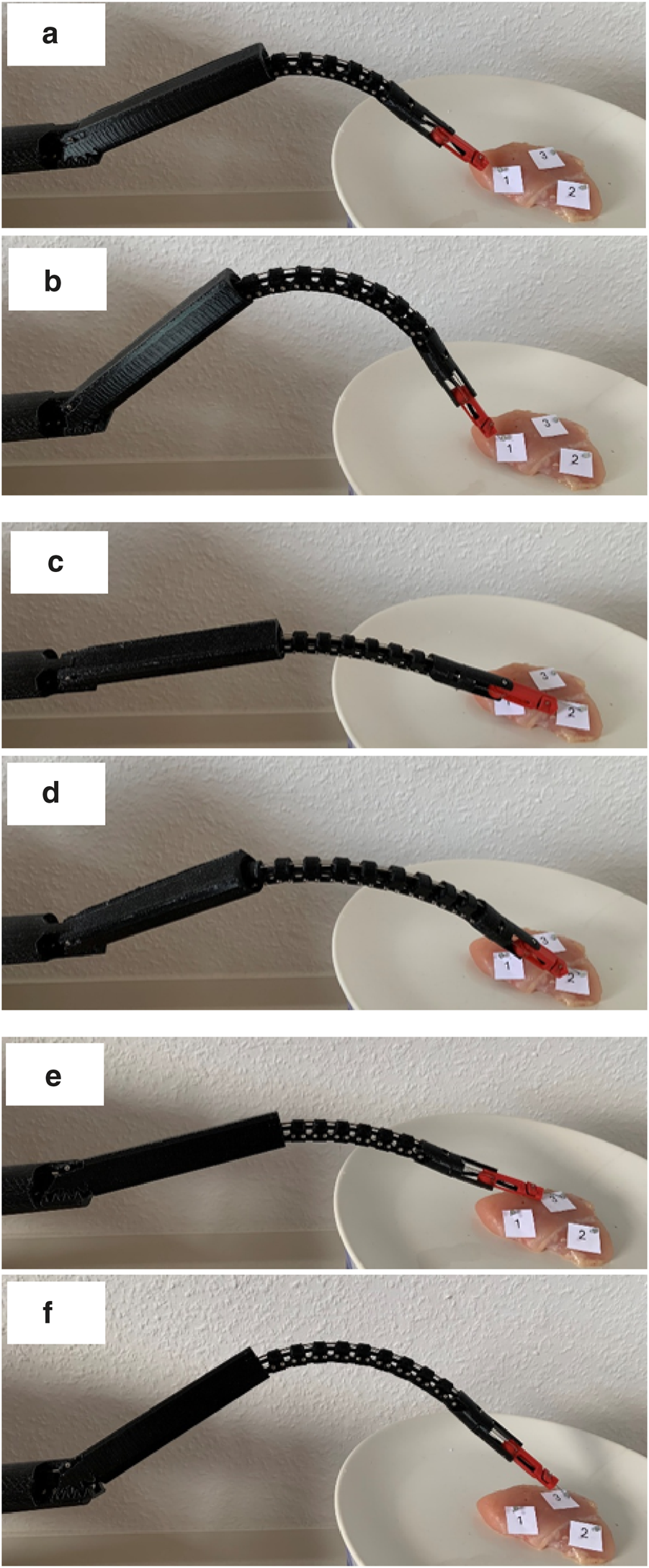 A black robotic arm with a flexible structure manipulates a piece of raw chicken on a plate across six panels labeled a to f. The chicken is marked with numbered labels. The arm demonstrates different gripping positions and angles, engaging with the chicken at various points.