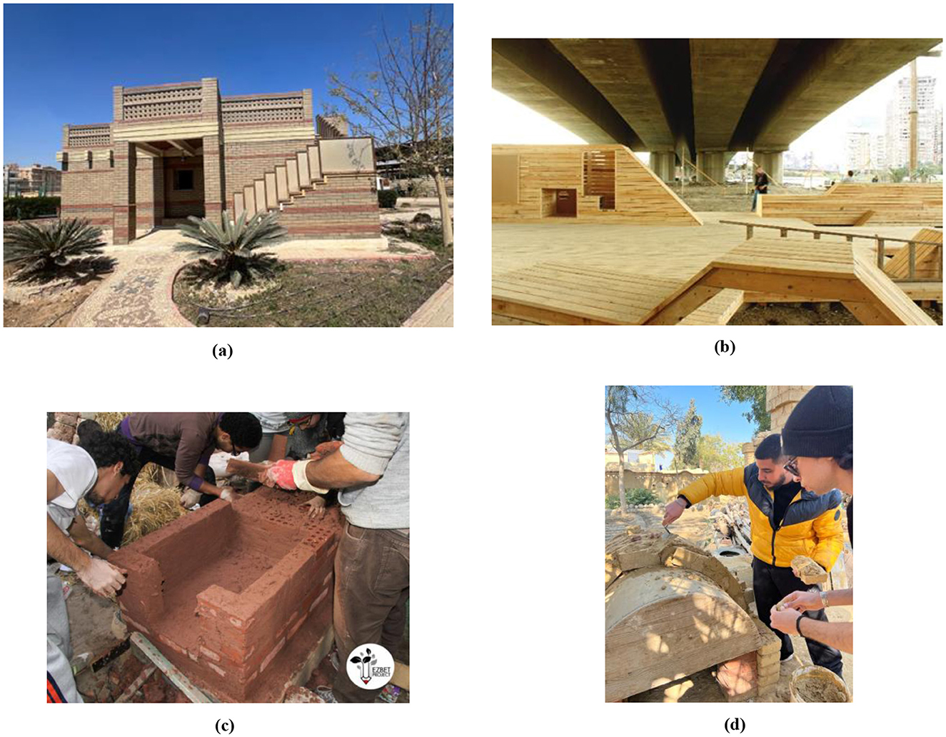 (a) A small brick building with decorative patterns, flanked by two plants, under a clear blue sky. (b) A wooden deck structure beneath a concrete overpass with urban buildings in the background. (c) People working together to build a red brick structure outdoors. (d) Two individuals applying materials to a dome-shaped wooden structure in a sunny outdoor area.