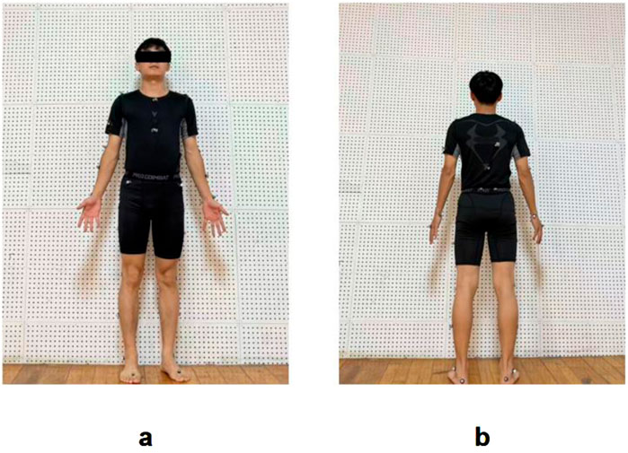 Person wearing a black athletic outfit stands against a perforated wall in two poses. In image a, the individual faces forward with arms by their sides and feet apart. In image b, they are turned away from the camera, showing their back.