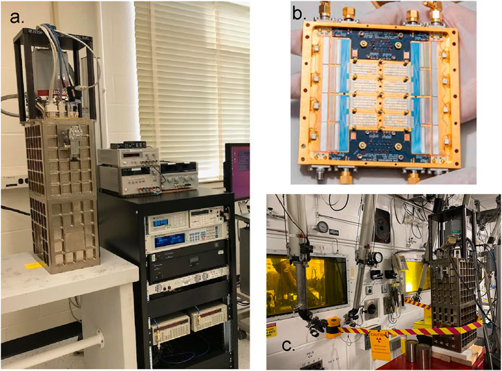 a. Laboratory setup with electronic equipment, including a tall, rectangular apparatus connected to various measurement devices on a table and rack.b. Close-up of a the TES array with multiple components, encased in a yellow frame, held by a person.c. Industrial setting with a similar tall, rectangular apparatus inside a containment unit, surrounded by machinery and safety barriers.