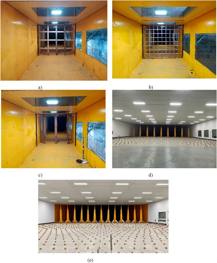 Panels showing different sections of a testing facility. Panel (a) shows a yellow walled tunnel with wooden beams. Panel (b) features a similar tunnel with a metal grid. Panel (c) depicts another view of the tunnel. Panel (d) is a large room with numerous ceiling lights and objects arranged in a grid on the floor. Panel (e) shows a similar room with objects arranged more densely.