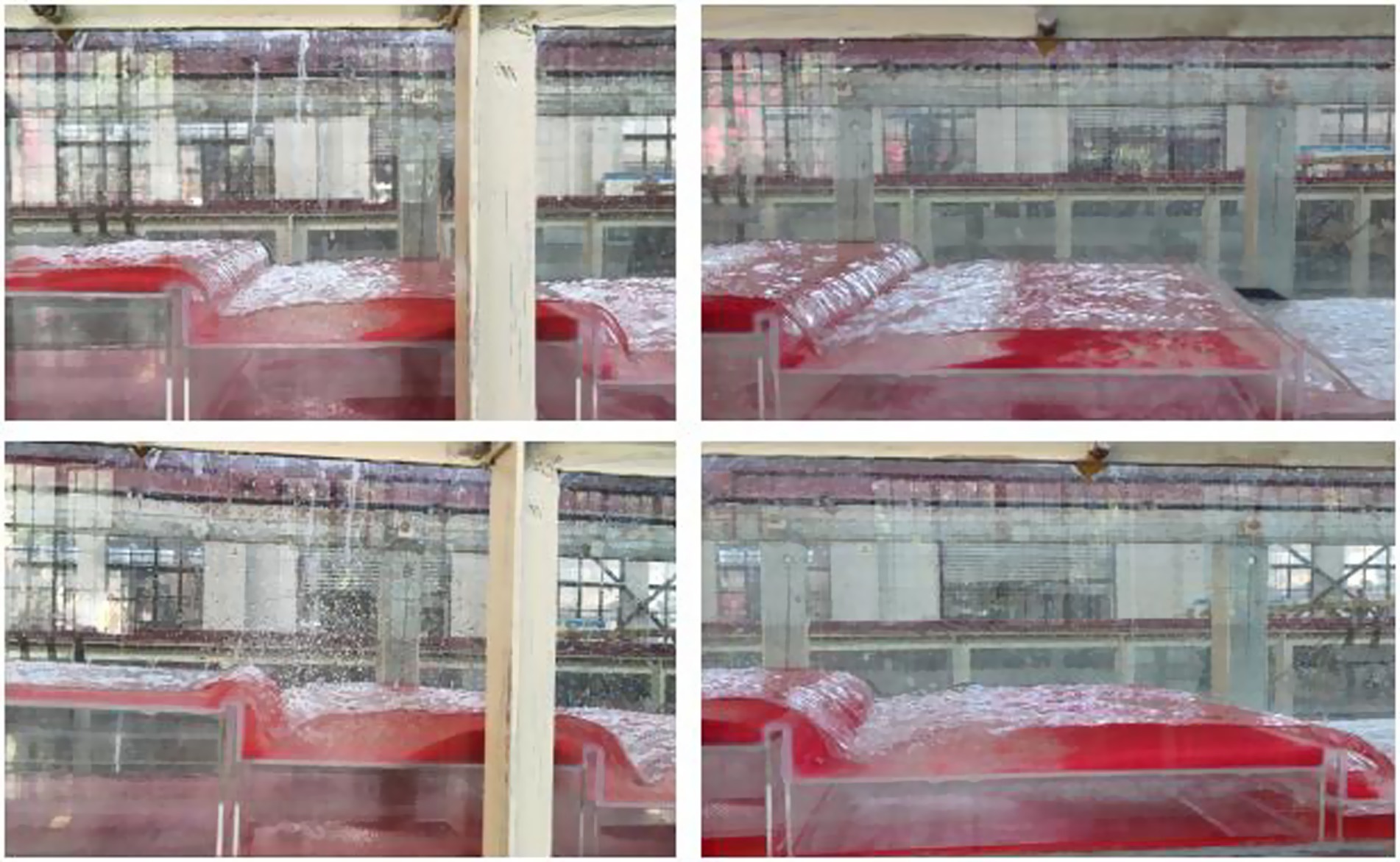 Water flows over a transparent surface covering red objects in a four-panel sequence. The background shows an industrial building with large windows. Each panel depicts the water forming waves as it moves over the red objects.
