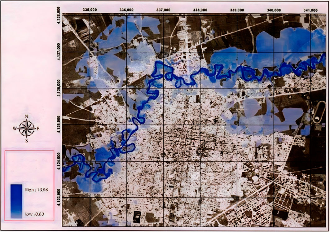 A topographic map shows a river meandering through an urban area. The river is highlighted in blue, surrounded by a mix of urban structures and open spaces. Grid coordinates and a compass rose are present, indicating orientation. A color gradient legend on the left shows elevation levels, from low in light blue to high in dark blue.