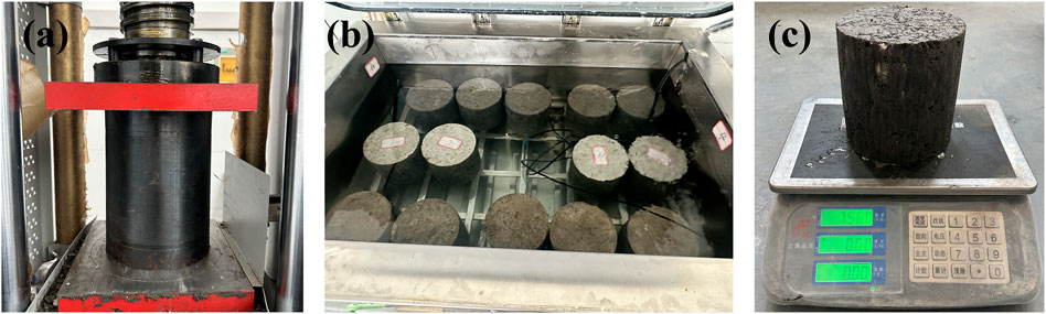 Panel (a) shows a compression machine with a black cylindrical specimen between red supports. Panel (b) displays several concrete cylinders submerged in water within a metal tank. Panel (c) features a cylindrical sample on an electronic scale with a reading of 7.56.
